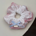 Dettaglio di elastico a righe blu e rosa con pizzo bianco e fiocco fatto a mano - Elastico Rosa con Fiocco