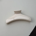 Top view of a minimalist creamy white glossy hair claw clip for elegant bun hairstyles - Arch Style