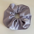 Detail showing lilac purple cloth scrunchie with handmade woven label and neat stitching - Purple