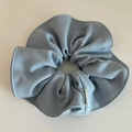 Close-up of light blue scrunchie showing twill fabric texture and fine stitching detail - Blue