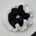 Λεπτομερής προβολή του ασπρόμαυρου scrunchie με βολάν και υφές υφάσματος σε στρώσεις - Μαύρο
