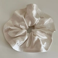 Close-up of elegant champagne satin oversized scrunchie with detailed stitching - Off-white