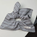 Détail d'un chouchou à rayures avec nœud et étiquette Smile Life en tissu de coton et de lin - Chouchou Foulard Bleu-Gris