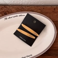 Close-up of amber acetate hair clips with Barrette La France engraving on a ceramic plate - Yellow