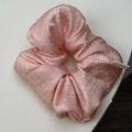 Detalle de coletero rosa plisado con textura satinada y etiqueta de tela hecha a mano - Rosa