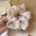 Close-up of champagne satin oversized scrunchie with soft silk luster and rich pleats - Champagne