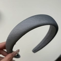 Dettaglio del cerchietto in tessuto grigio con trama a saia e design imbottito - Cerchietto Spesso / Cerchietto Grigio