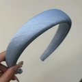 Dettaglio di un cerchietto imbottito azzurro con tessuto a saia tenuto in mano - Cerchietto Spesso / Cerchietto Blu