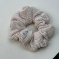 Detailansicht des cremefarbenen Strick-Scrunchie mit Waffelstruktur und M.Hua Etikett - Cremeweißer Waffel-Strick-Haargummi (XY-1779) / Off-White Haargummi
