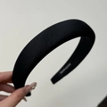 Macro detail of handmade black fabric headband with sponge padding and white woven label - Black Headband