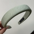 Detail showing the light green textured fabric and thick padded design of the headband - Green Headband