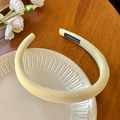 Gros plan d'un bandeau éponge jaune épais fait main avec une finition satinée sur une assiette - Jaune