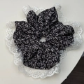 Primer plano de coletero floral negro con bordes de encaje blanco y textura delicada - Estilo de Encaje Negro