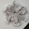Detalle de coletero floral grande con bordado de encaje blanco y patrones de flores grises - Encaje Beis