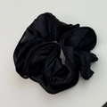 Close-up of black oversized scrunchie with layered chiffon ruffles for elegant hair styling - Black