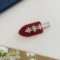 Detail der roten Haarspange mit silbernen Metallblumen und eingelegten Strasssteinen - Rot