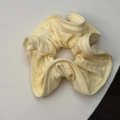 Detail of light yellow ribbed knit fabric on a scrunchie showing soft textile texture - Yellow