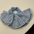 Gros plan d'un chouchou à carreaux bleus et blancs avec des volants en tissu de coton - Rose bonbon