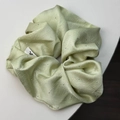 Dettaglio dello scrunchie in raso verde chiaro con strass argento scintillanti ed etichetta - Verde