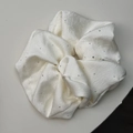 Vista dettagliata dell'elastico in raso crema con strass scintillanti e trama plissettata - Bianco Sporco