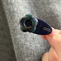 Détail d'une pince à cheveux goutte indigo faite main avec fleur 3D et logo doré - Fleurs Aux Teintes Bleues Et Vertes