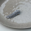 Dettaglio del fermaglio per capelli in cristallo a foglia su vassoio ceramico - Stile Foglia Piuma Strass (B款)