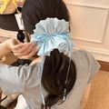 Détail d'un chouchou en dentelle bleu clair avec long ruban sur une coiffure en queue de cheval - Bleu