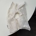 Detailaufnahme weißer Mesh-Haargummi mit gestickten Schleifen und gewebtem Etikett-Design - Off-White (Schal-Stil)