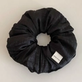 Minimalist black textured gauze hair scrunchie with a handmade label on a clean surface - Black