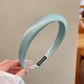 Detailed shot of mint green satin padded headband featuring a handmade inner label - Satin Style