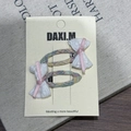Détail de deux barrettes à rayures violettes avec dentelle sur une carte support - Paire de Pinces à Cheveux Noeud