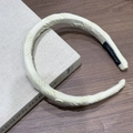 Detail van een crème gewatteerde haarband met textuur en handgemaakt label op houten achtergrond - Roomgeel Hoofdband