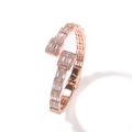 Detail eines roségoldenen Hip-Hop-Armreifs mit überkreuzten Reihen von Zirkoniasteinen - Roségold