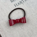 Detail of red acetate bow hair tie with gold France Handmade logo and elastic band - Red