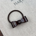 Detailed macro view of deep brown acetate bow hair tie with gold France Handmade lettering - Brown