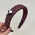 Macro detail of the hand-made fabric label inside the red and green plaid headband - Headband