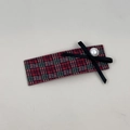 Detalle de pinza para el pelo a cuadros rojos y verdes con lazo negro y perla elegante - Pinza Cuadrada
