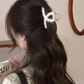 Detail of plush cross claw clip in cream white holding long wavy hair for autumn style - Small Beige