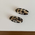 Detailed macro view of a pair of vintage oval leopard print hair clips with glossy finish - Oval Clip / Beige Stripes
