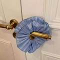 Dettaglio dell'elastico per capelli a righe azzurre con piccola etichetta bianca a coniglio - Blu