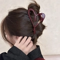 Detail of burgundy heart-shaped hair claw clip with gold script lettering on a bun - Wine Red Heart