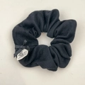 Dettaglio scrunchie nero in maglia a coste con fiocco fatto a mano ed etichetta orso - Nero