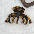 Detail of tortoiseshell hair claw clip with gold France Handmade logo on white textured background - Pumpkin Style Dark Tortoiseshell