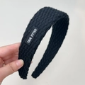 Primer plano de diadema de punto grueso negro con textura y etiqueta de logotipo blanca - Negro