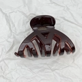 Dettaglio del fermaglio a conchiglia marrone con logo dorato fatto a mano in Francia - Cioccolato