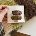 Detail view of handmade brown knit and plush hair clips on white packaging card - Brown