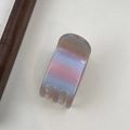 Makro-Detail einer französischen Haarklammer aus Acetat mit elegantem Gold-Schriftzug - Blau & Rosa