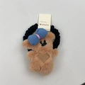 Detalle de coletero de osito de peluche marrón con lazo de cuadros azul y corazón bordado - Lazo de Pelo Oso Caqui