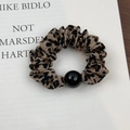 Close-up of leopard print scrunchie with a glossy black bead detail on a clean background - Light Beige Leopard (Style A)