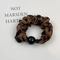 Detail of leopard print scrunchie with a black glossy bead on white paper - Dark Coffee Leopard (Style D)